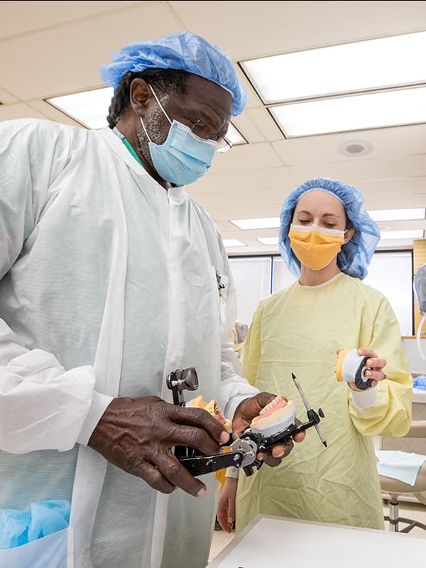 Dr. Alvin Rembert, a faculty member in the School of Dentistry who practices at the G.V. “Sonny” Montgomery Veterans Affairs Medical Center, discusses a mold of a patient’s teeth with fourth-year student Christina Legradi in the Restorative Clinic.